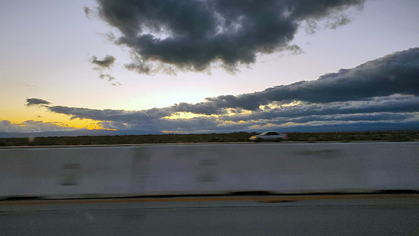 Looking west from the 14 Freeway north of Lancaster. The sun is setting and clouds are in the sky.